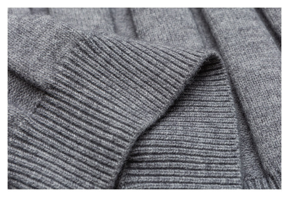 Close-up of a gray knit garment showing a wide ribbed cuff against the knit body.