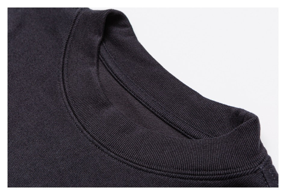 Close-up of a dark crewneck collar with ribbed trim and visible stitching.