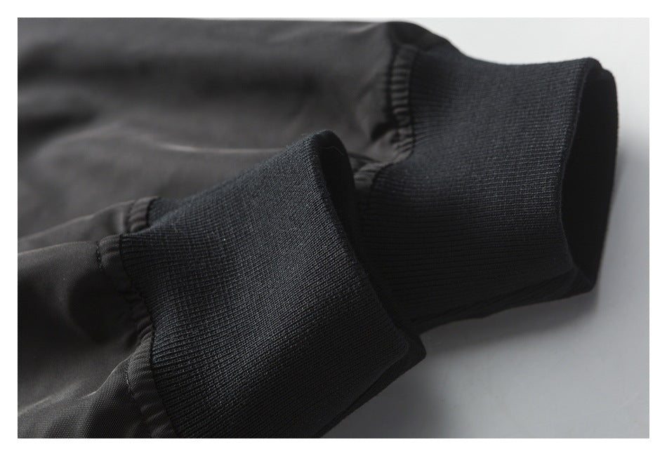 Close-up of the black bomber jacket's ribbed knit cuff and adjoining sleeve fabric.