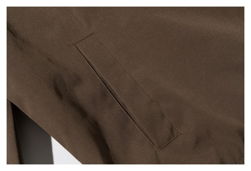 Close-up of a slanted welt pocket on a brown jacket.