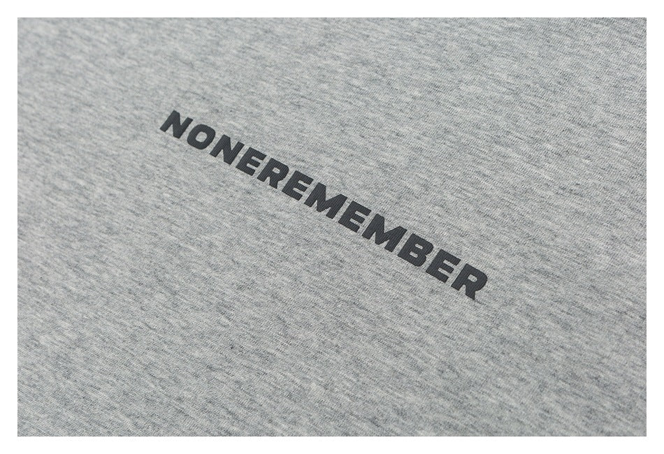 Close-up of a heather-gray T-shirt with black NONEREMEMBER lettering.