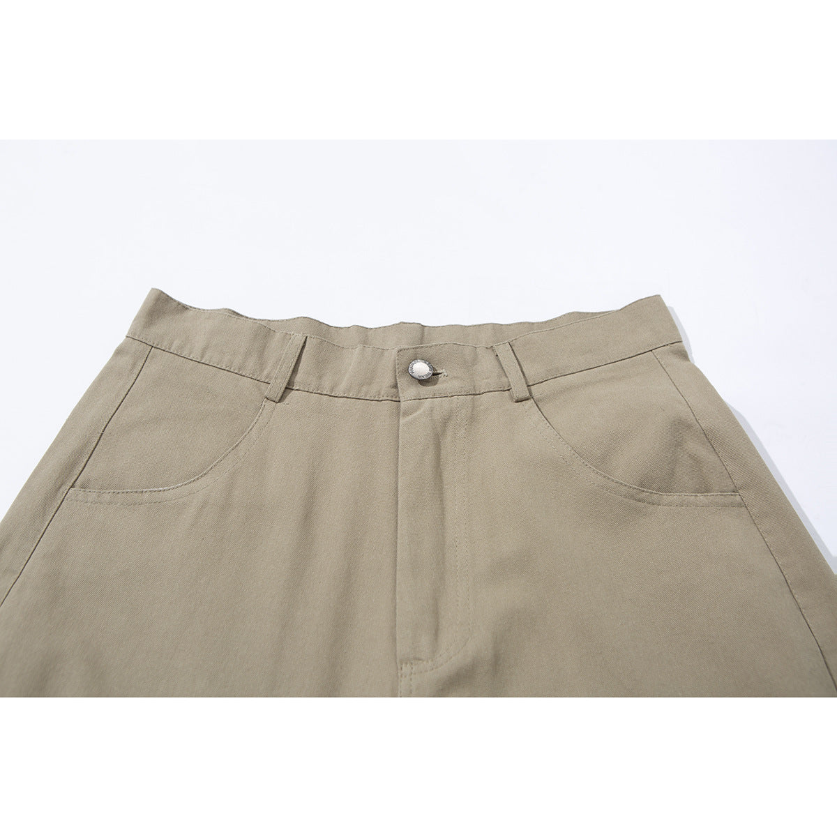 Close-up of beige trousers showing the waistband, button closure, belt loops, and curved front pockets.