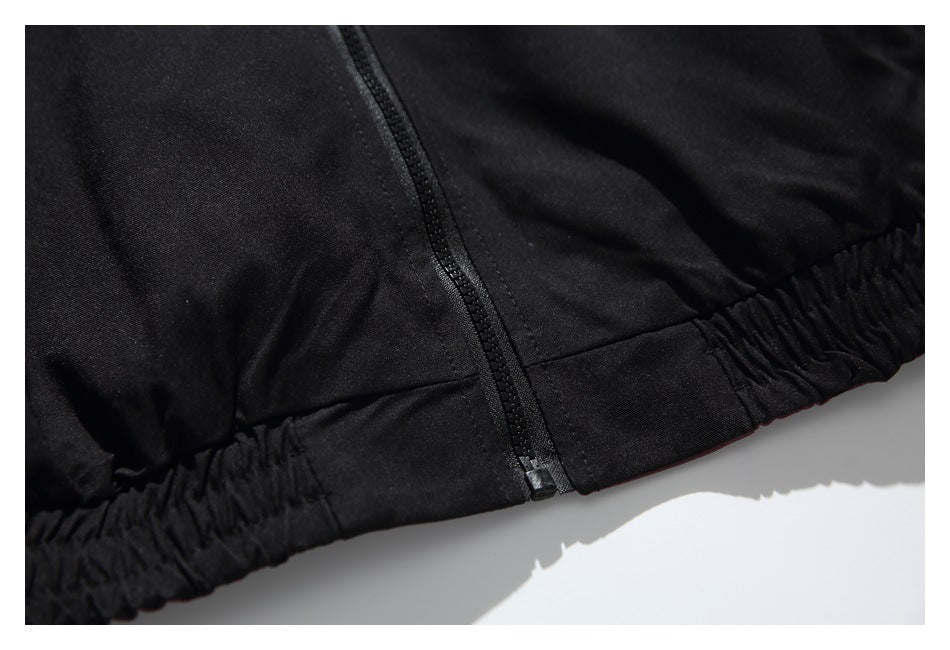 Close-up of the black jacket's zipper end and gathered elastic hem.