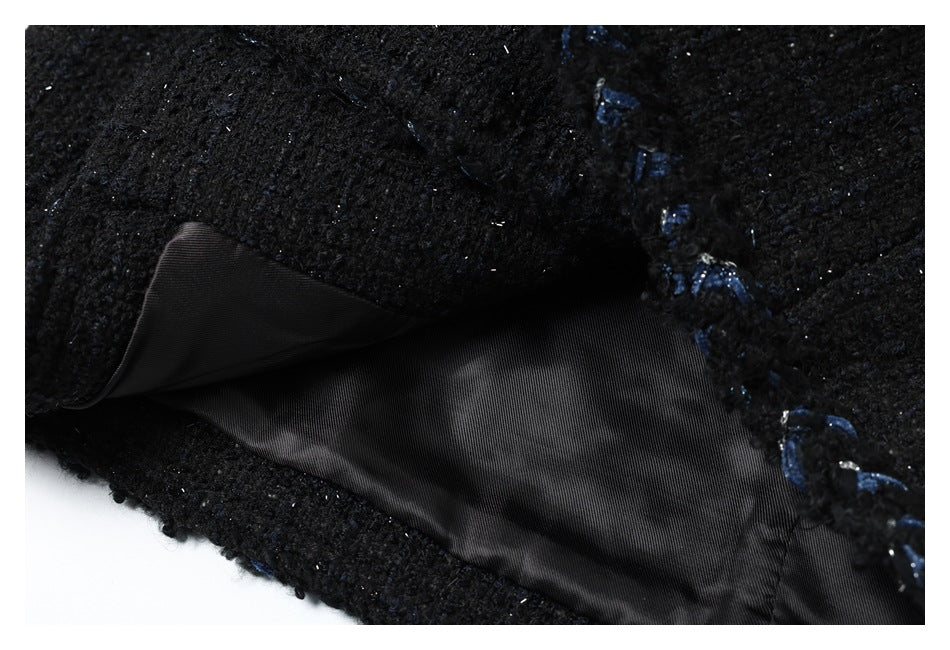 Close-up showing the black garment's smooth dark lining and blue stitched edge.