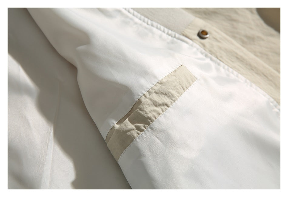 Close-up of an ivory garment's lining and stitched seam with a contrasting fabric strip.