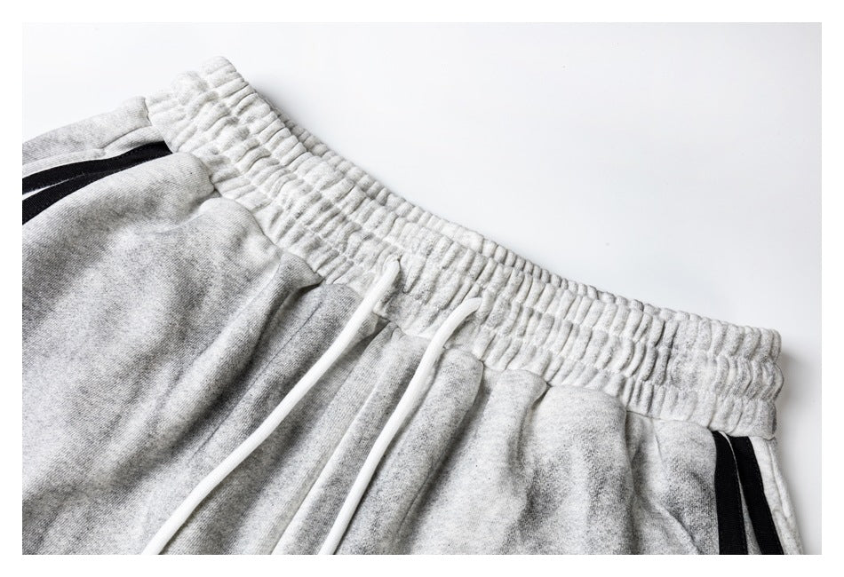 Close-up of light gray jogger shorts showing the gathered elastic waistband and white drawstrings.