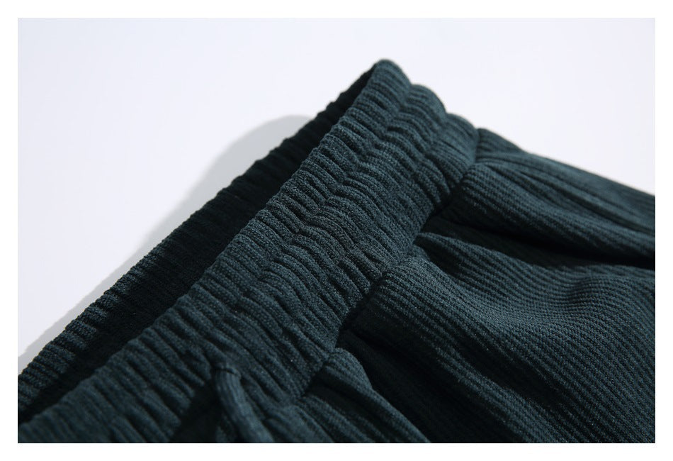 Close-up of dark teal ribbed pants showing the gathered elastic waistband.