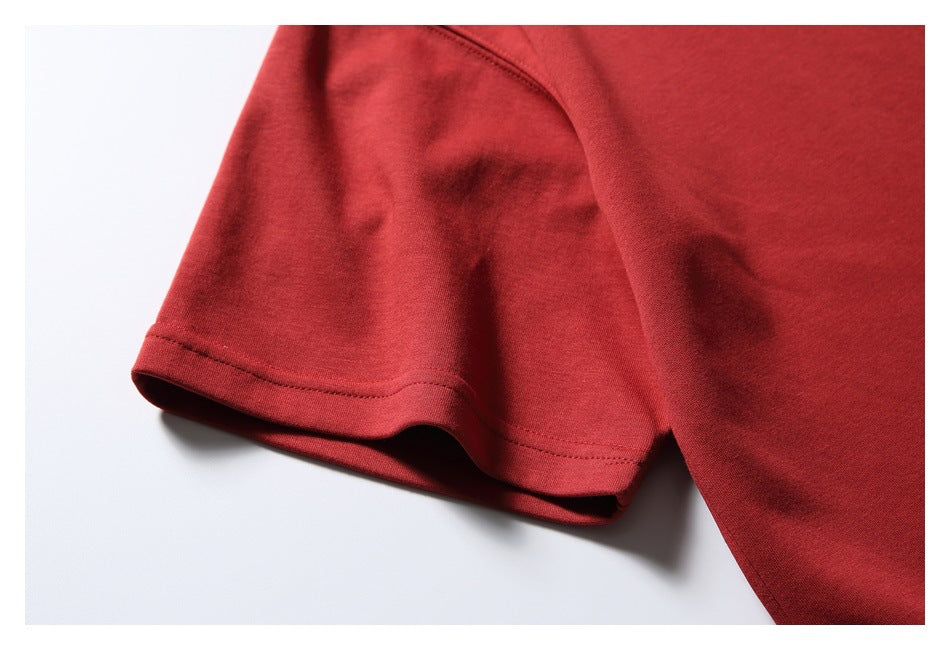 Close-up of a red T-shirt sleeve showing its folded, double-stitched hem.