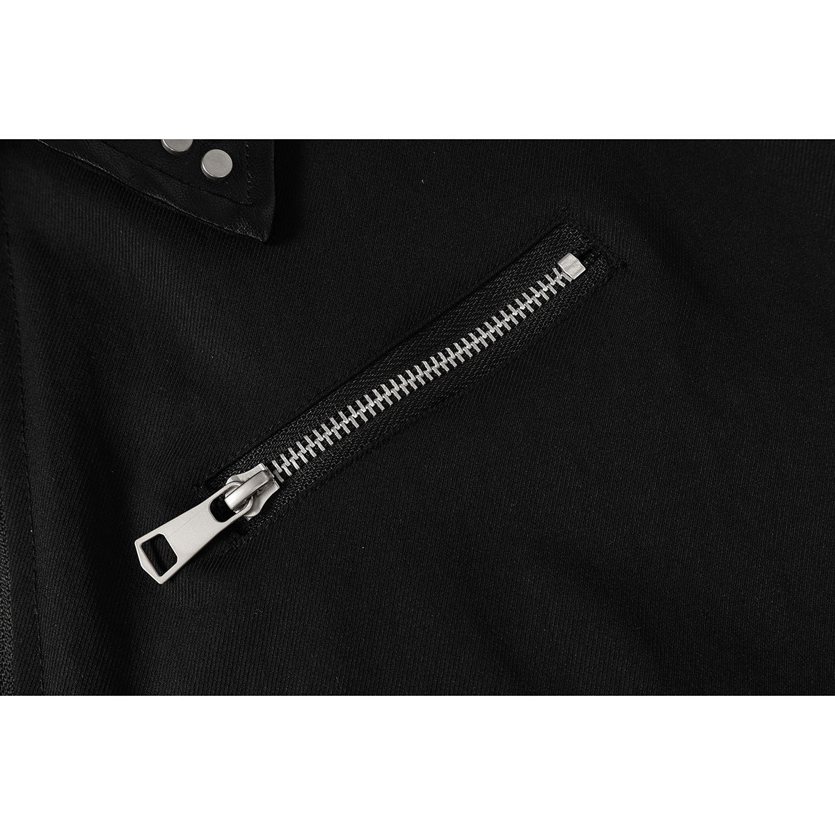 Close-up of a diagonal silver zipper on the black jacket.