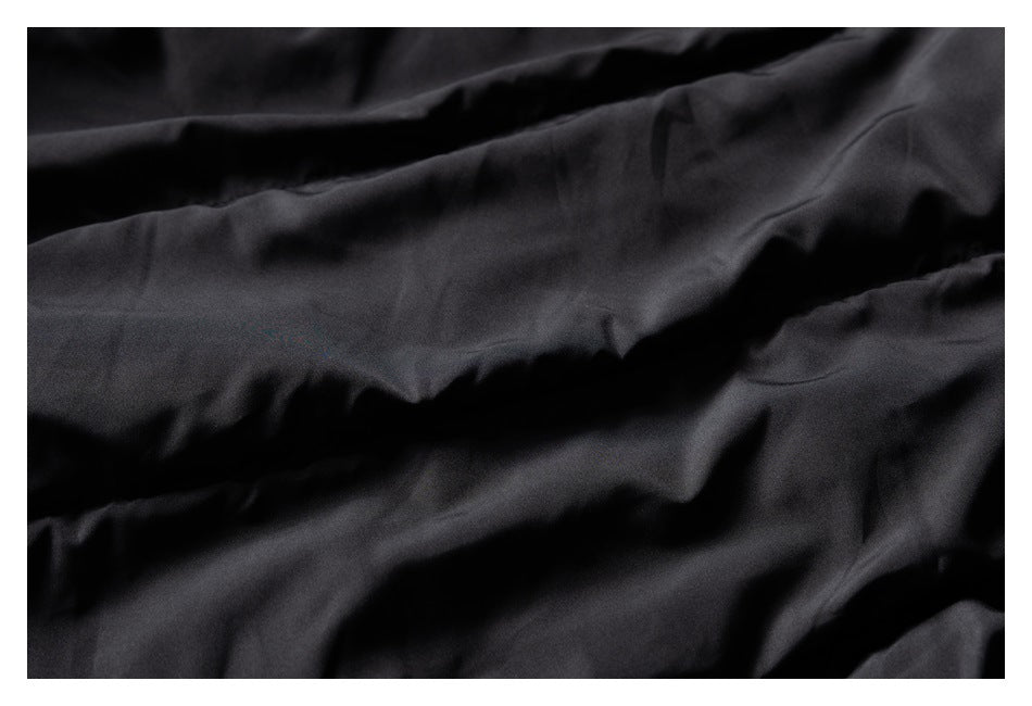 Close-up of black fabric gathered into soft folds.