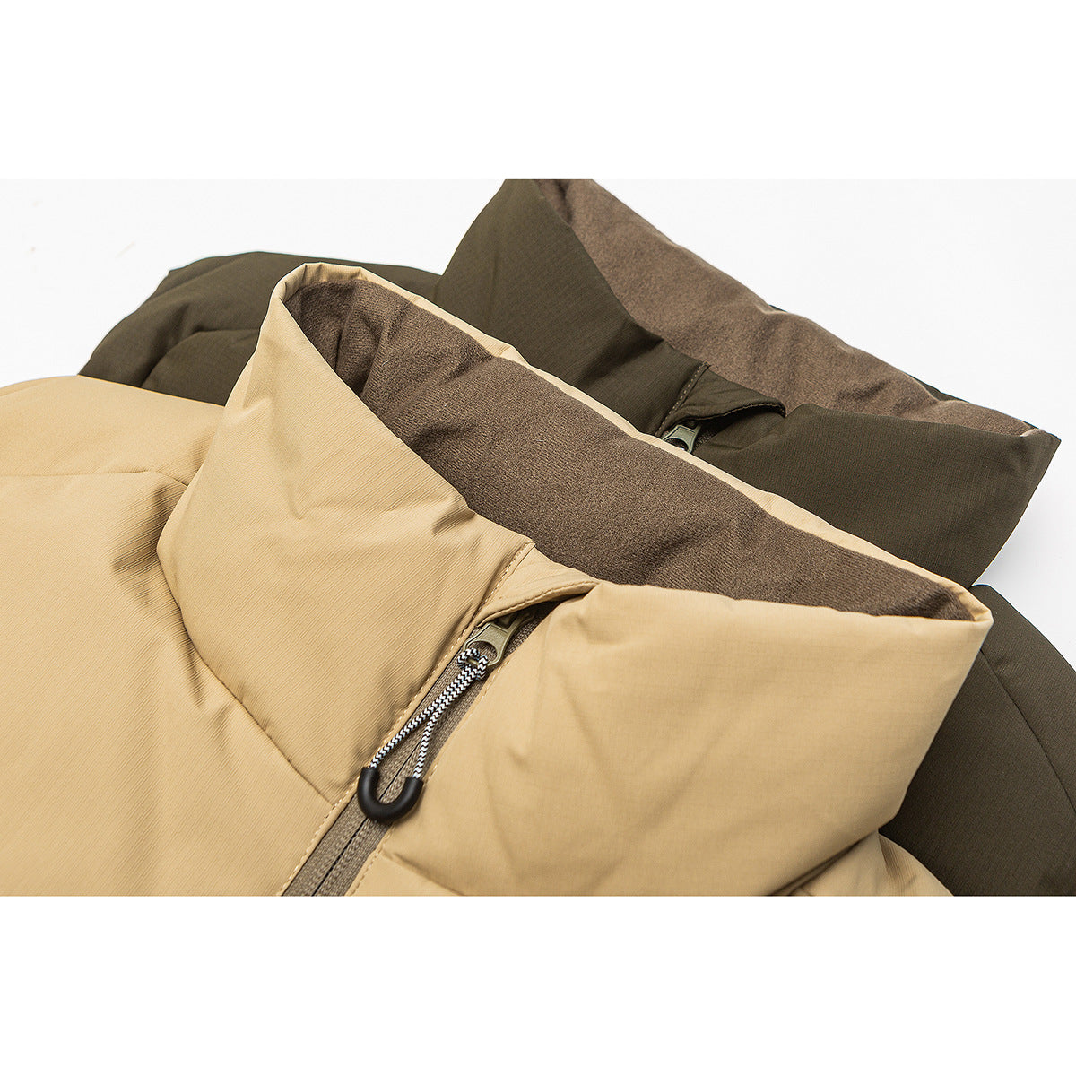 Close-up of tan and olive padded vests showing raised collars, brown lining and front zippers.