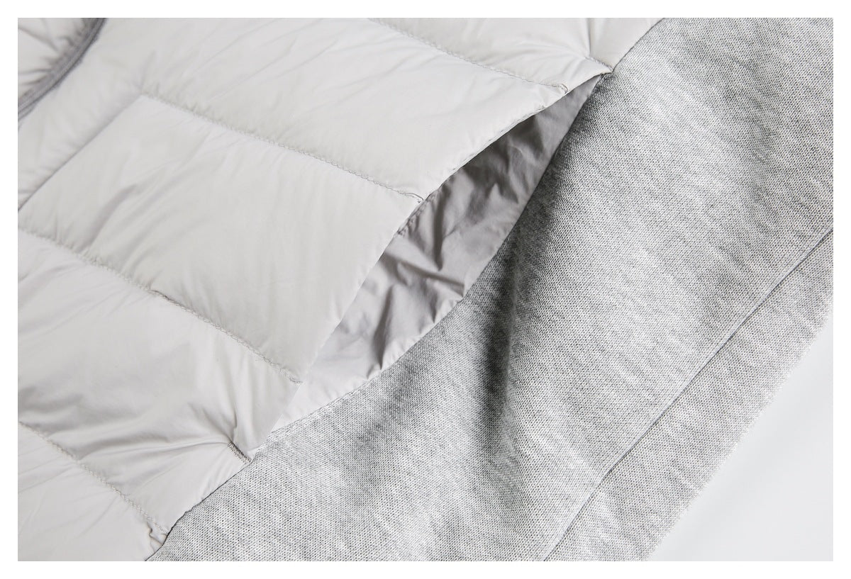 Close-up of a light gray quilted jacket beside a contrasting heather-gray knit panel.