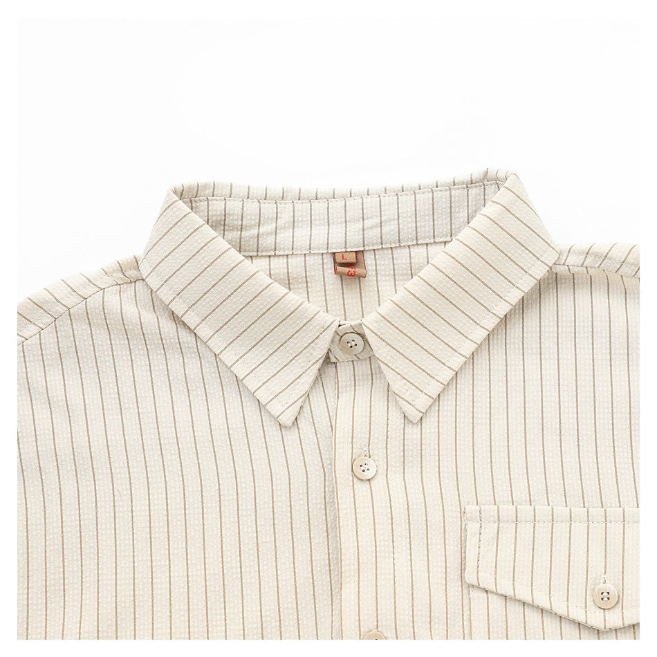Close-up of a cream shirt collar, buttons, and chest pocket with fine tan vertical stripes.