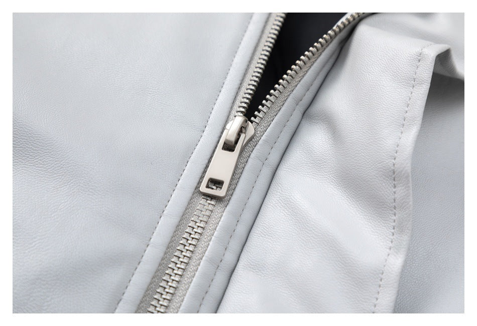 Close-up of a pale gray jacket with a diagonal silver zipper and stitched seams.