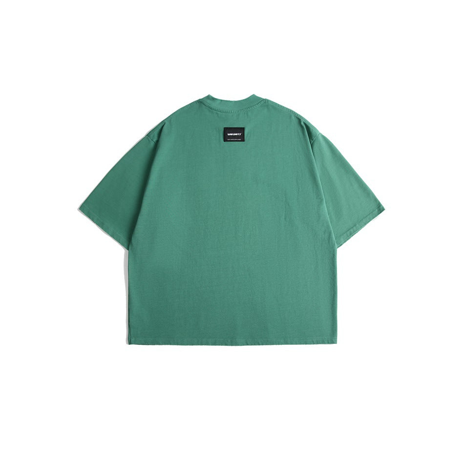 Back view of a teal green oversized short-sleeve crew-neck T-shirt with a small black label at the upper back.