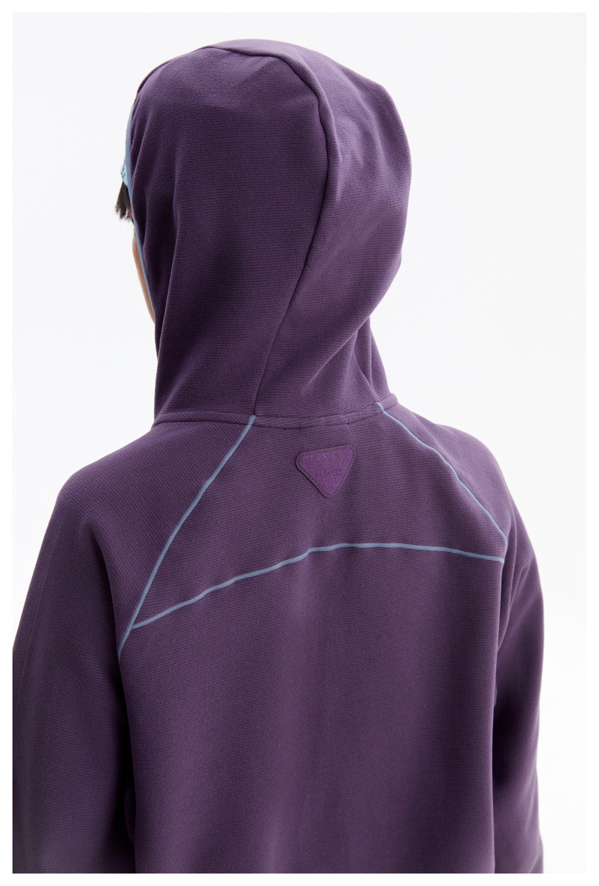 Rear close-up of a person wearing a purple hooded jacket with pale blue seam accents.