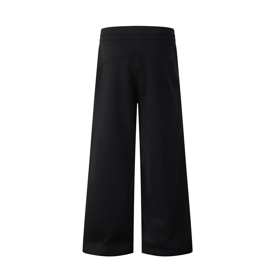 Back view of black wide-leg pants with an elastic waistband and plain, unadorned legs.