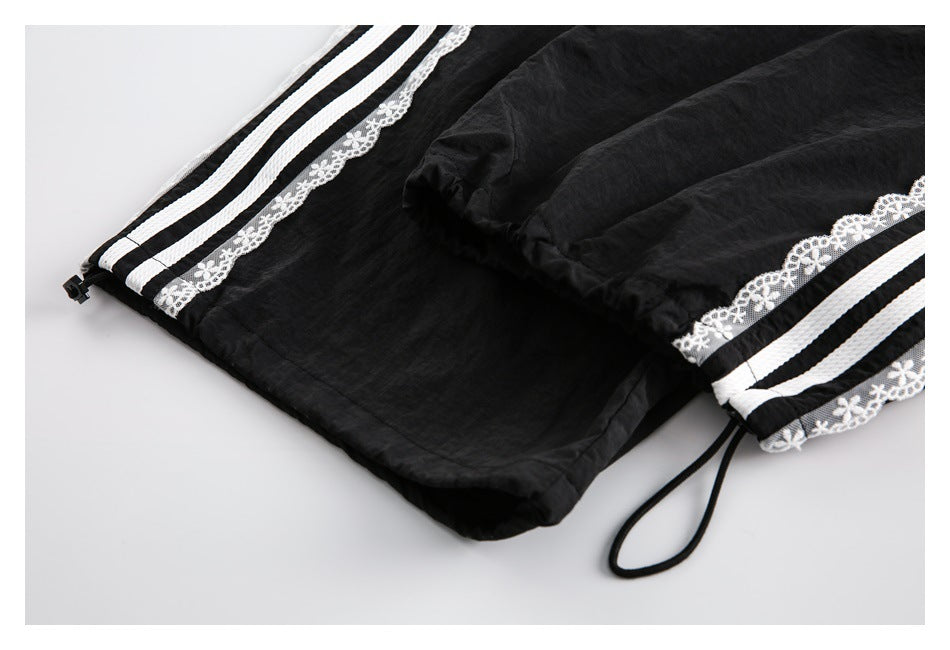 Close-up of the black pants hem with striped lace trim and an adjustable drawcord.