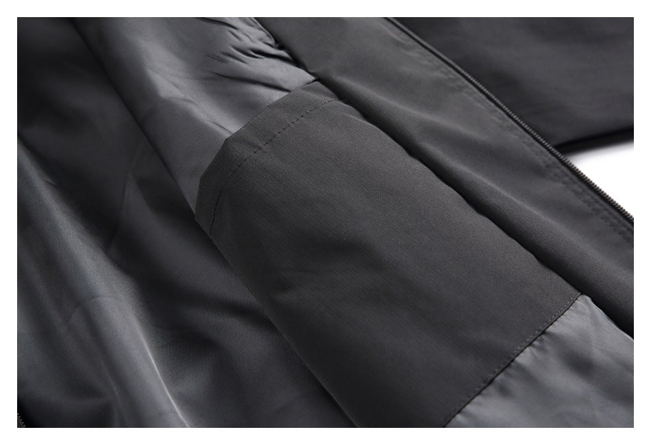 Close-up of a black zip-front garment showing a stitched panel and zipper.