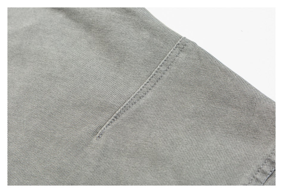 Close-up of gray garment fabric with a diagonal stitched seam.