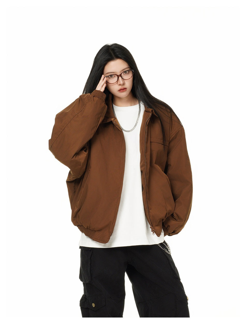 Model wearing an oversized brown zip-front jacket with a pointed collar, elastic cuffs and hem, and a chest pocket.