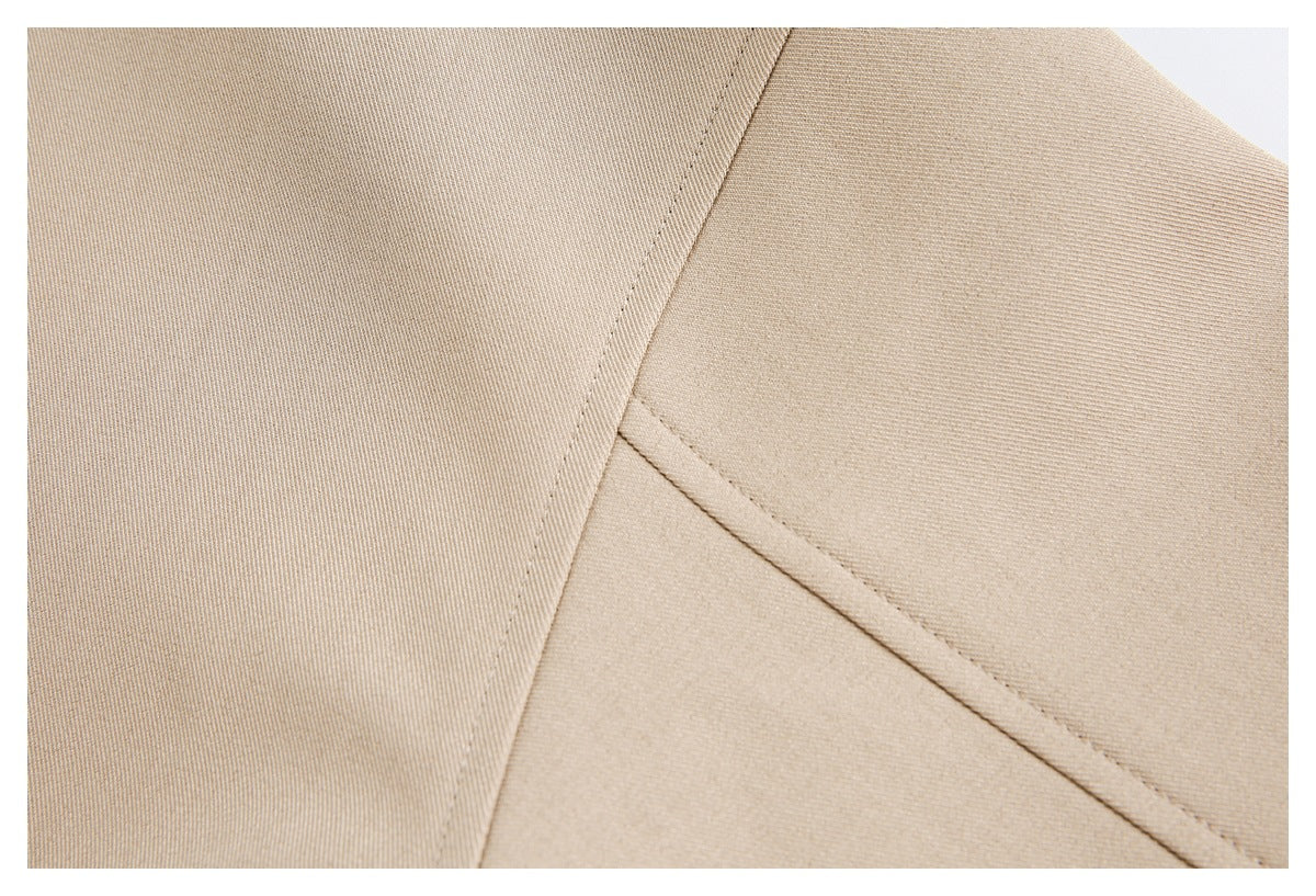 Extreme close-up of beige fabric panels meeting at a curved stitched seam.