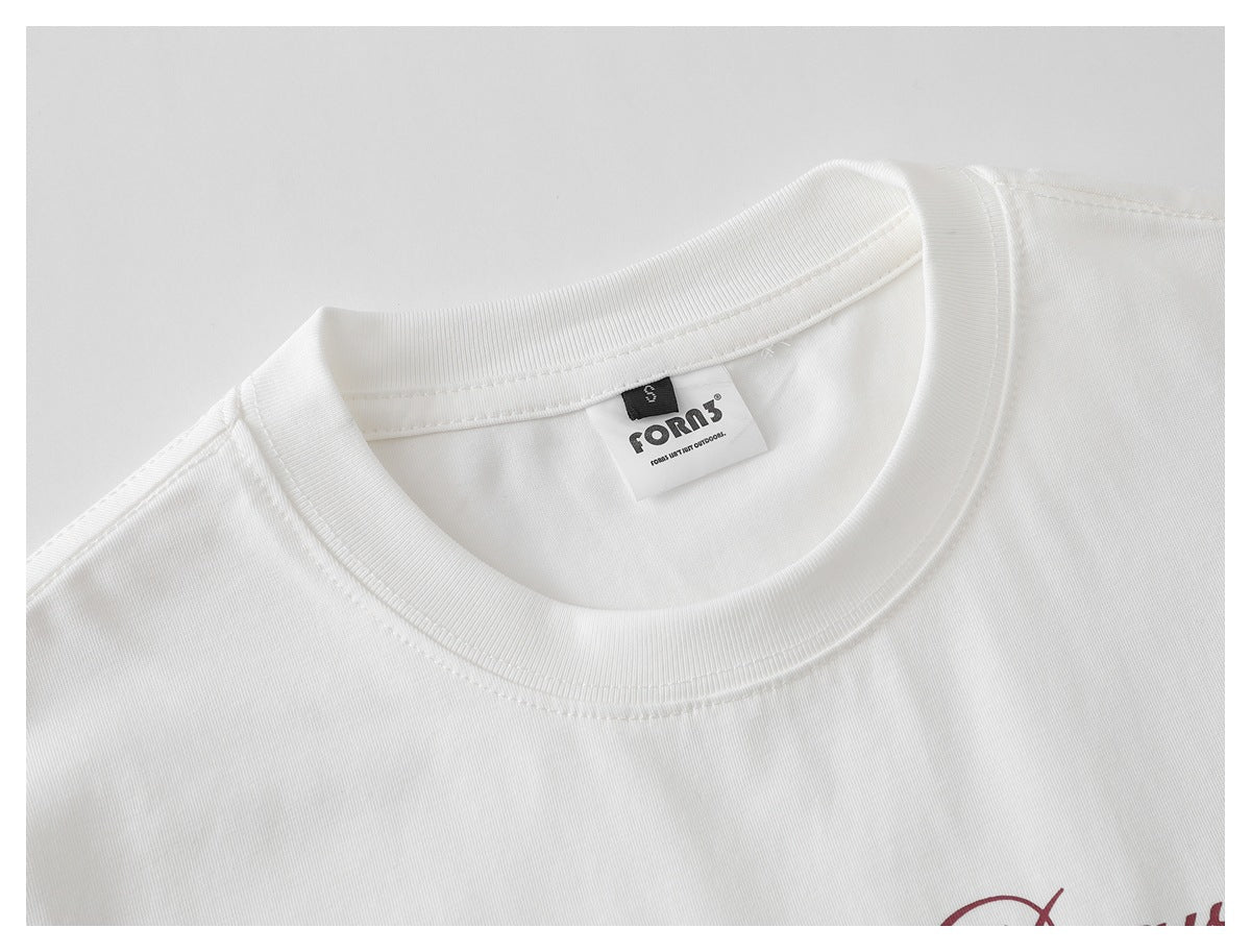 Close-up of a white T-shirt's ribbed crew neck, inner brand label, and a small portion of burgundy print.