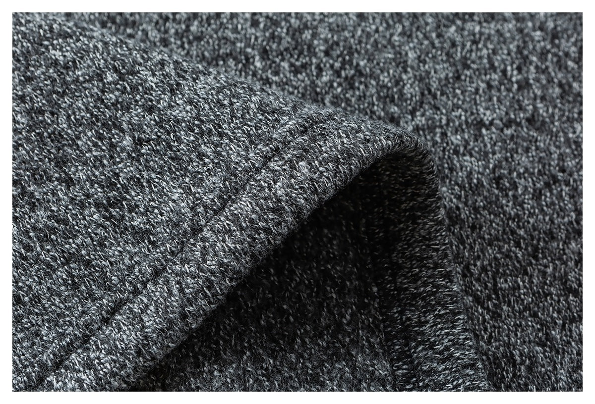 Macro view of the charcoal and light gray marled knit texture and folded edge.