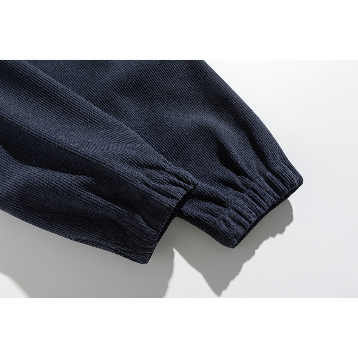 Close-up of the navy pullover’s gathered elastic sleeve cuffs and ribbed texture.