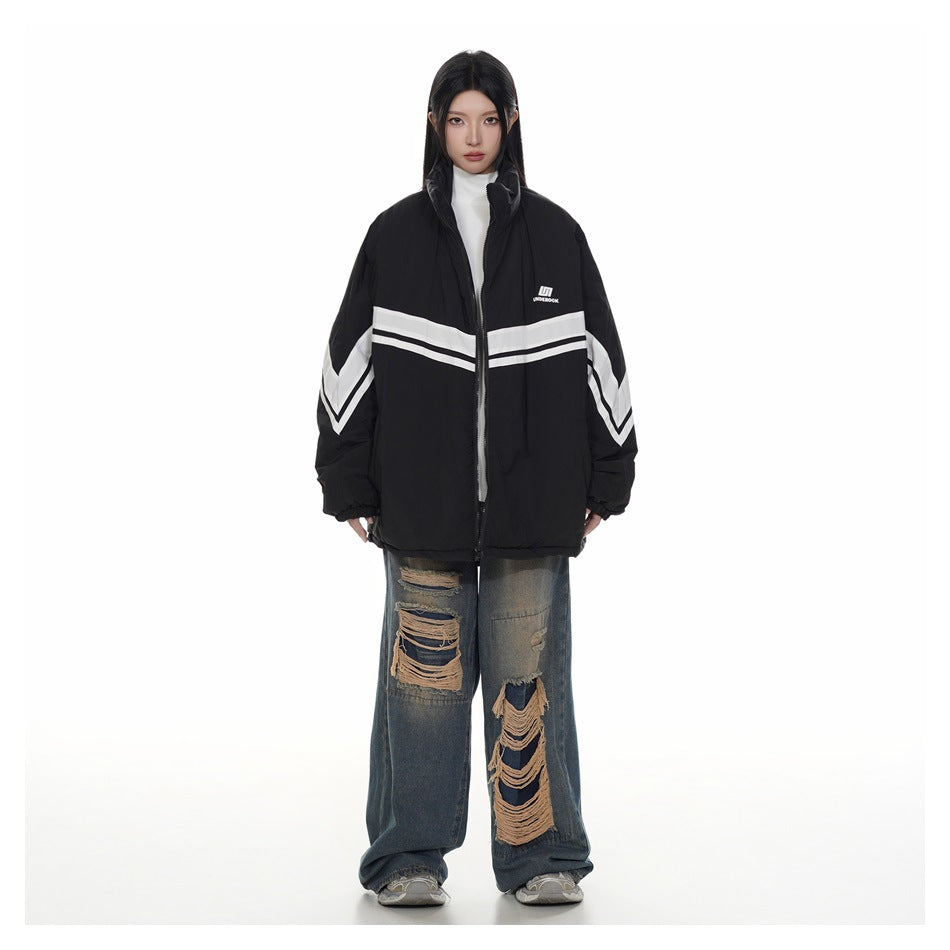 Full-length view of a model in a black oversized striped stand-collar jacket with a white top and wide-leg jeans