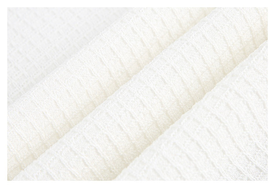 Macro view of white fabric folds showing a soft, textured woven surface.