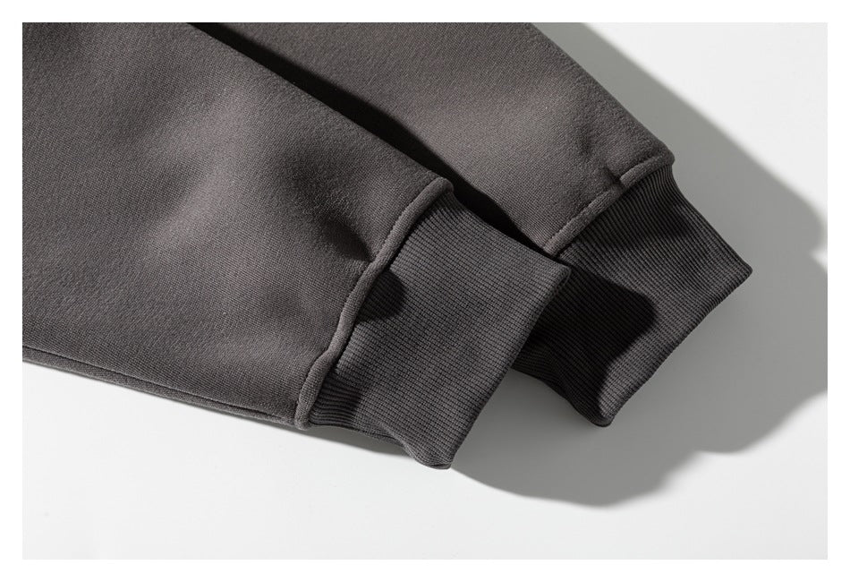 Close-up of two charcoal sweatshirt sleeves with wide ribbed cuffs.