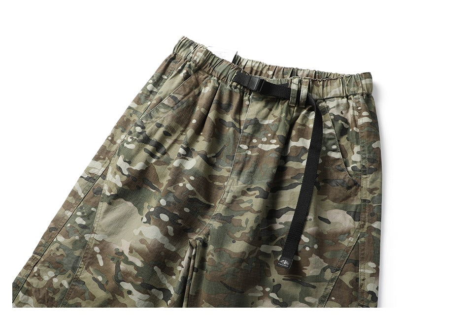 Front view of olive, brown, and black camouflage pants with an elastic waist and black webbing belt.