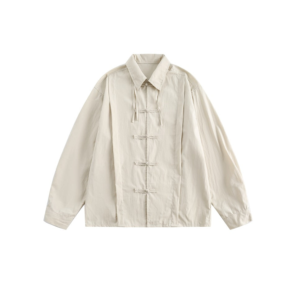 Beige long-sleeve collared shirt with five knotted fabric loop closures and tie strands at the collar, flat front view