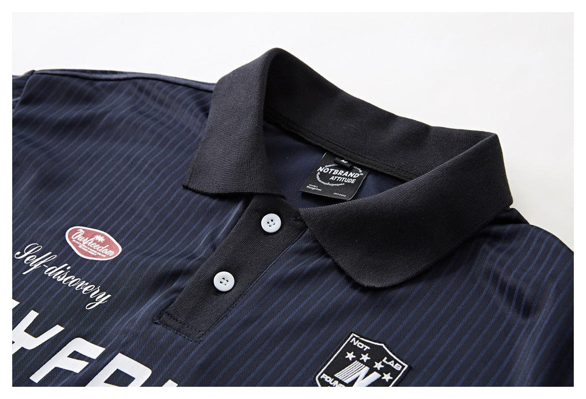 Close-up of a navy pinstriped polo shirt’s black collar, button placket, and chest graphics.
