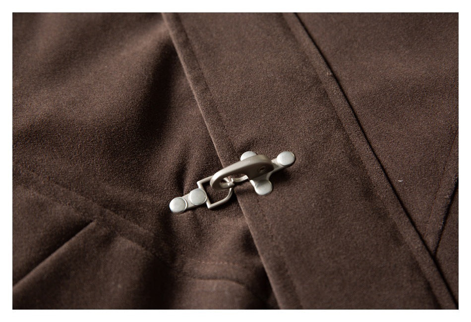Close-up of a brown coat showing its silver hook-and-loop clasp.