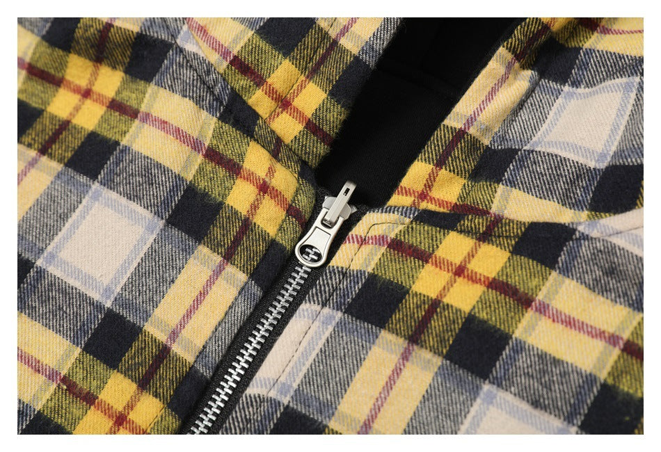 Close-up of the jacket's silver zipper against its yellow, cream, gray, and black plaid fabric.