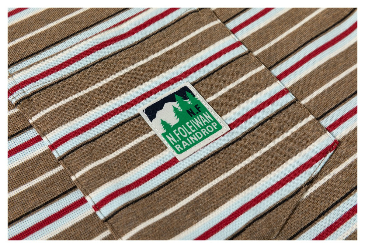 Close-up of the striped shirt's chest pocket and sewn green-and-black mountain patch.