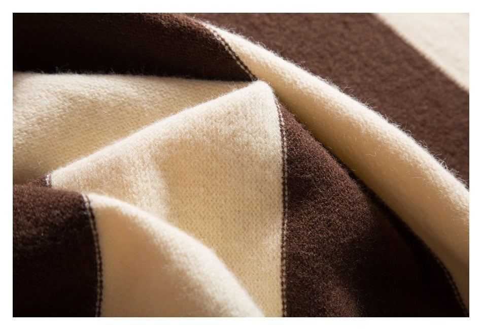 Close-up of folded cream and dark brown striped knit fabric showing its soft surface.