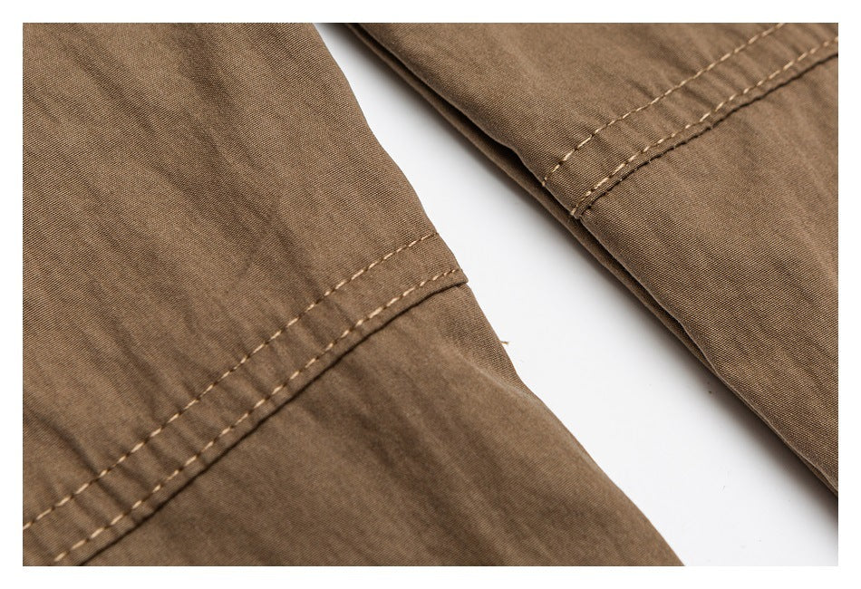 Close-up of brown trouser fabric with parallel stitched seam details.