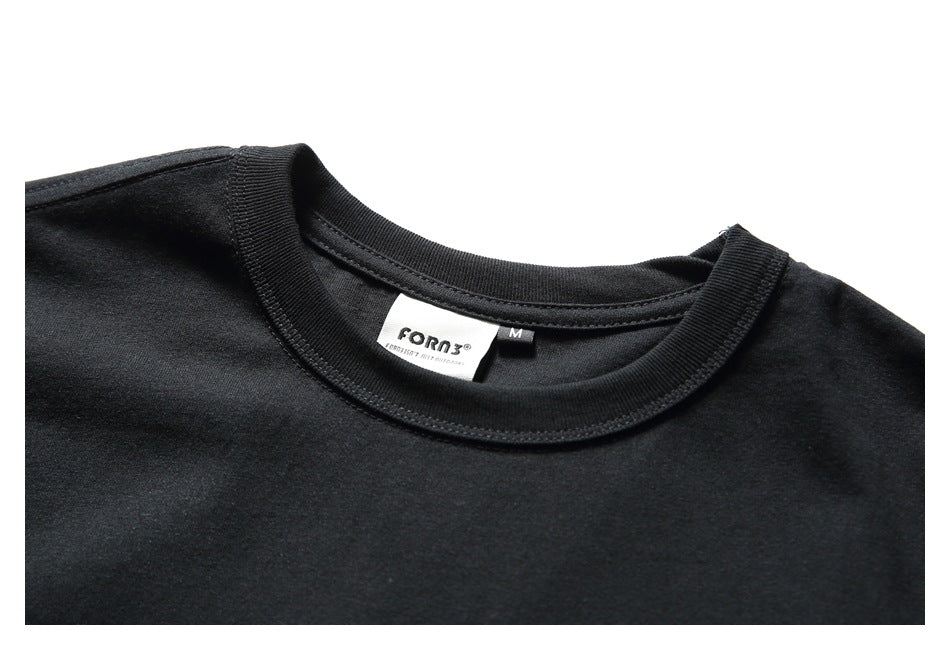 Close-up of a black T-shirt's ribbed crew neckline and inside brand and size labels.