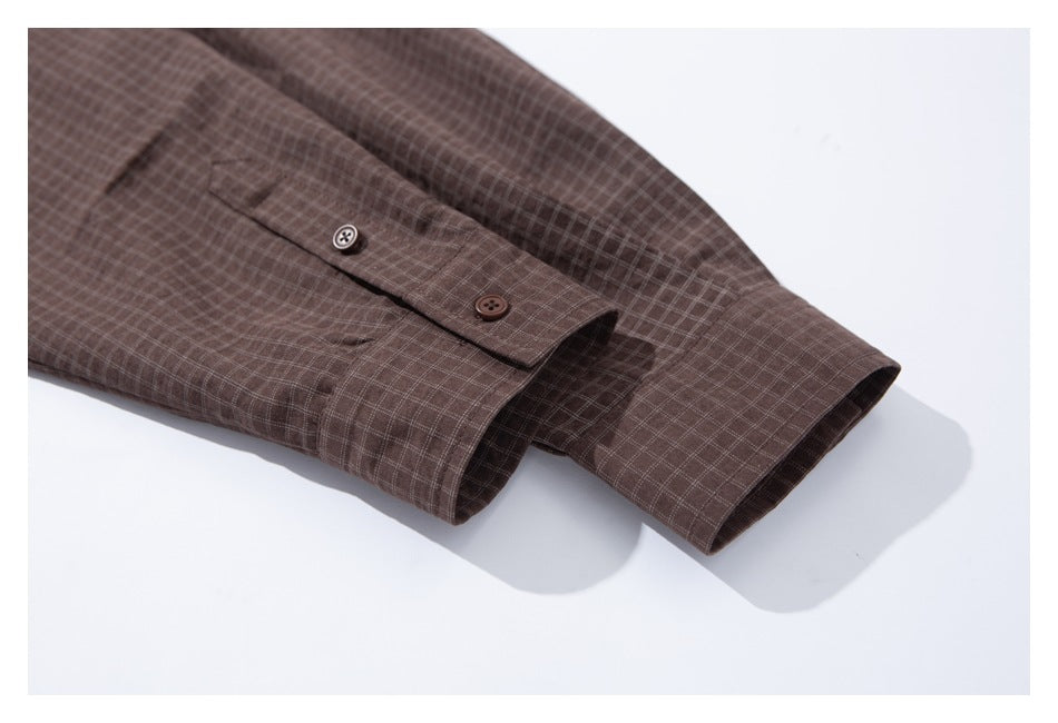 Close-up of the brown check shirt's buttoned cuffs and sleeves on a white background.
