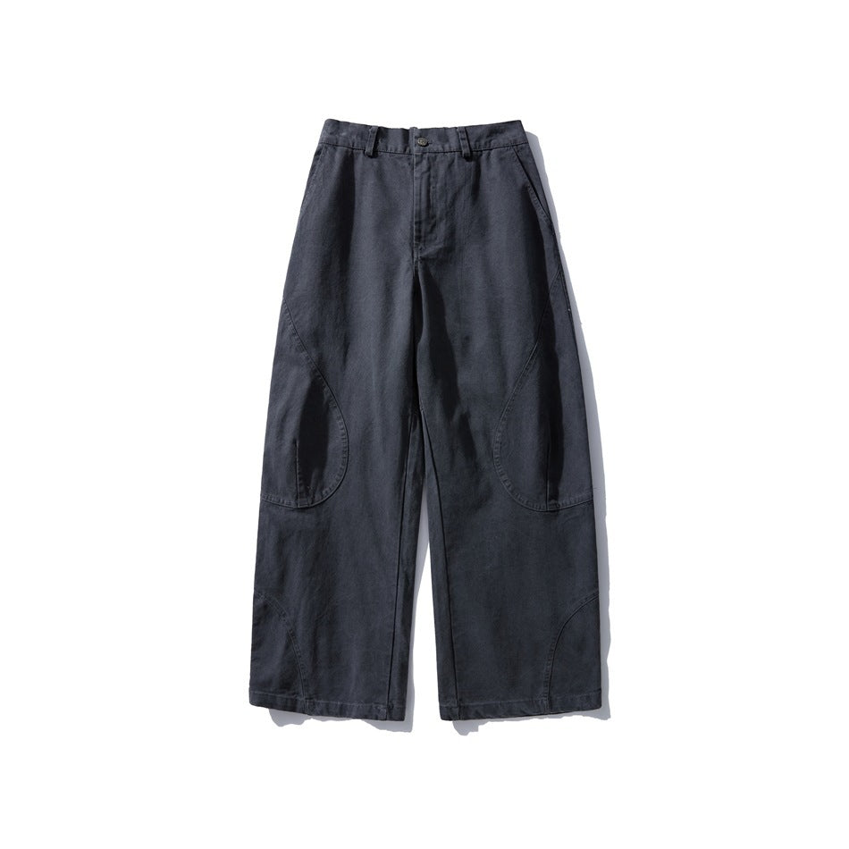 Front view of washed black wide-leg pants with button closure, belt loops and curved knee seams