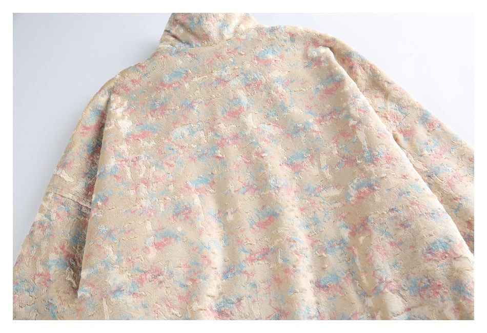 Back of a cream plush hooded jacket with an allover mottled pink and blue pattern.