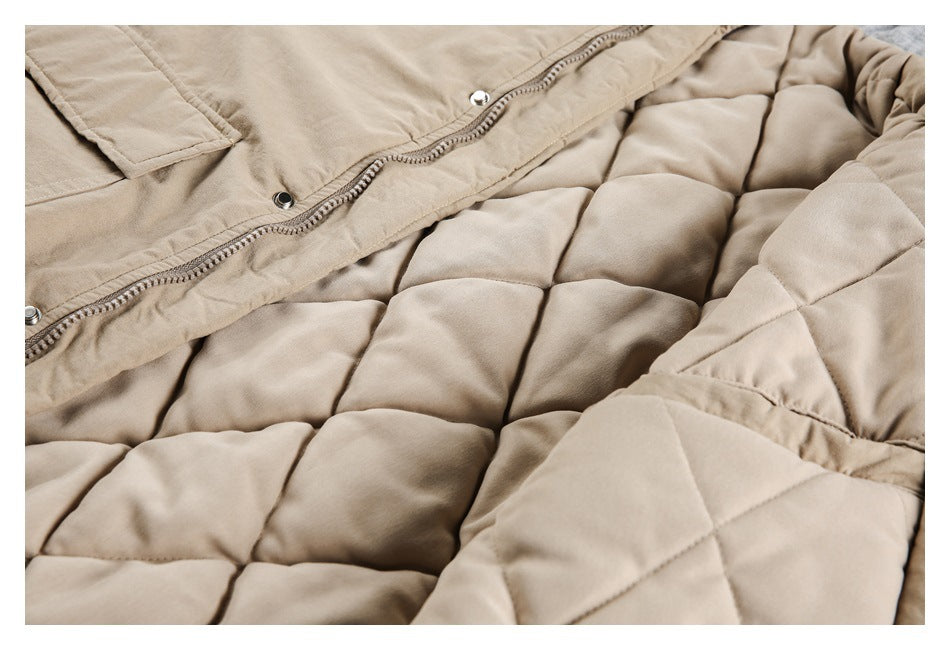 Close-up of a beige padded garment with quilted sections, zipper, and snap fasteners.