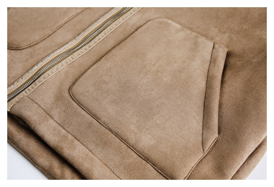 Close-up of a large stitched pocket and metal zipper on the tan jacket.