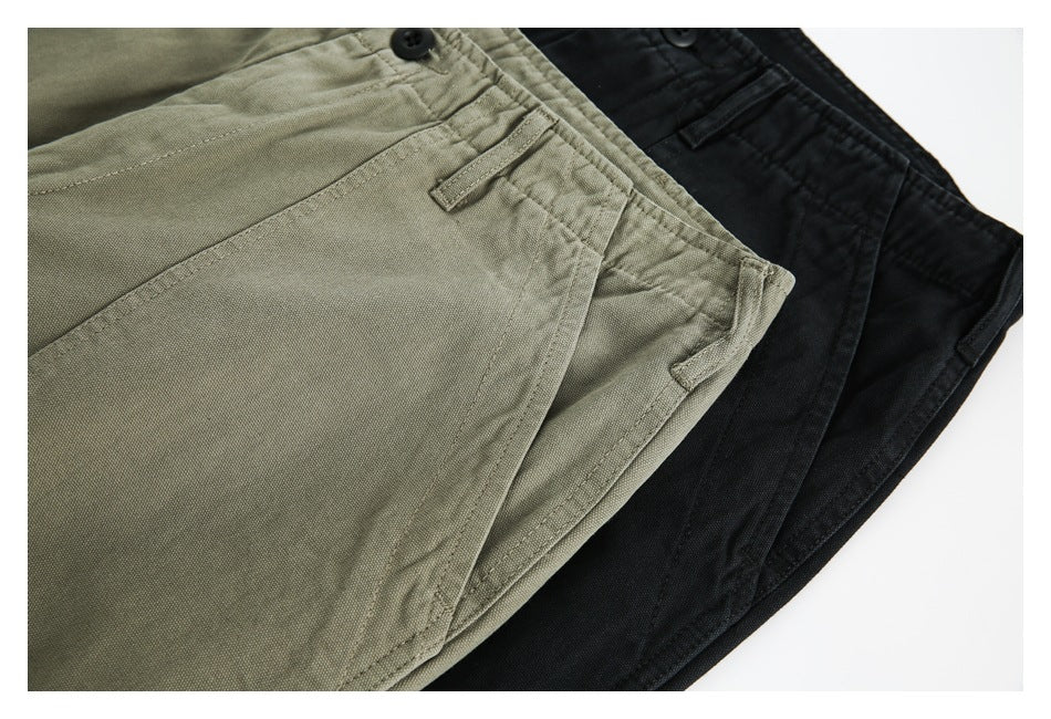 Close-up of olive and black trousers overlapping, showing front pockets, seams and waist details.