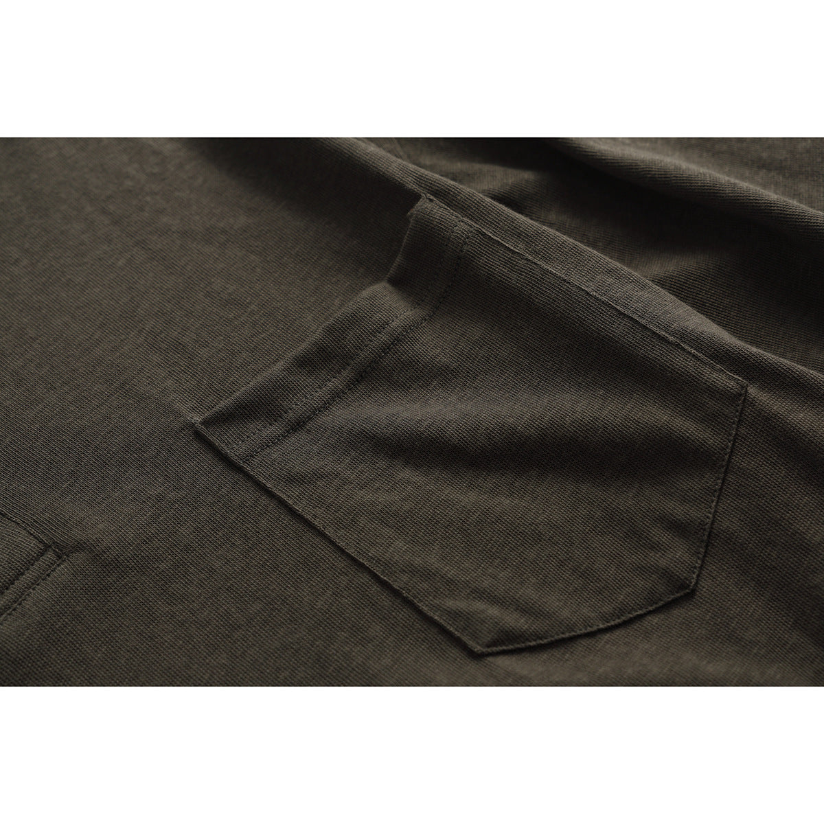 Close-up of a dark olive shirt's stitched chest pocket and textured fabric.