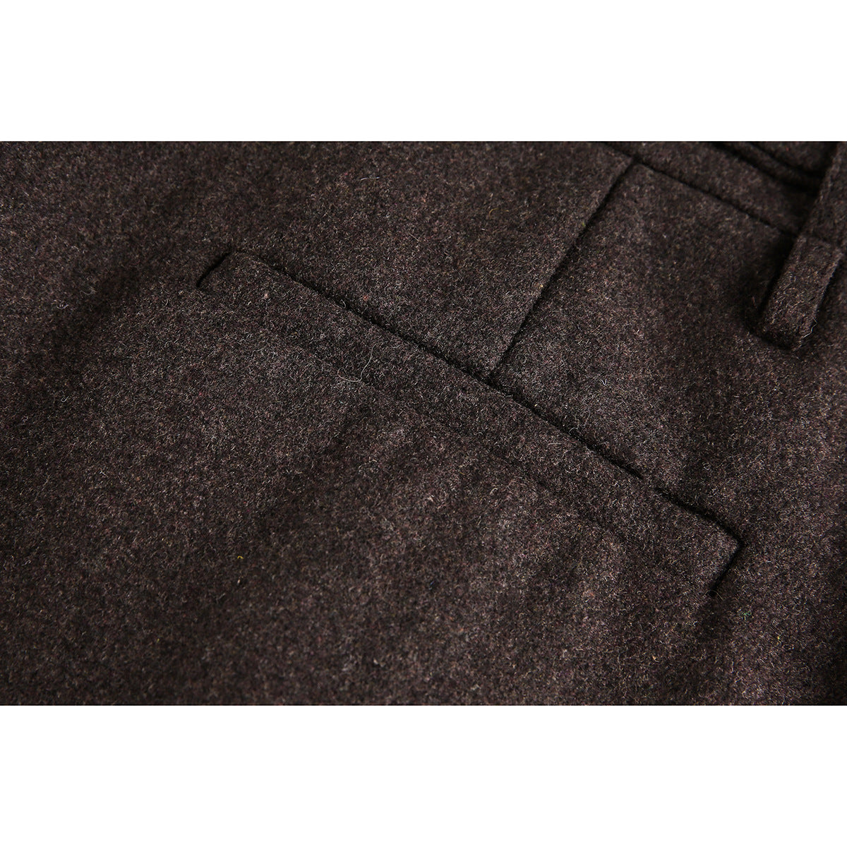 Close-up of brown trousers showing a slanted pocket and the textured surface.