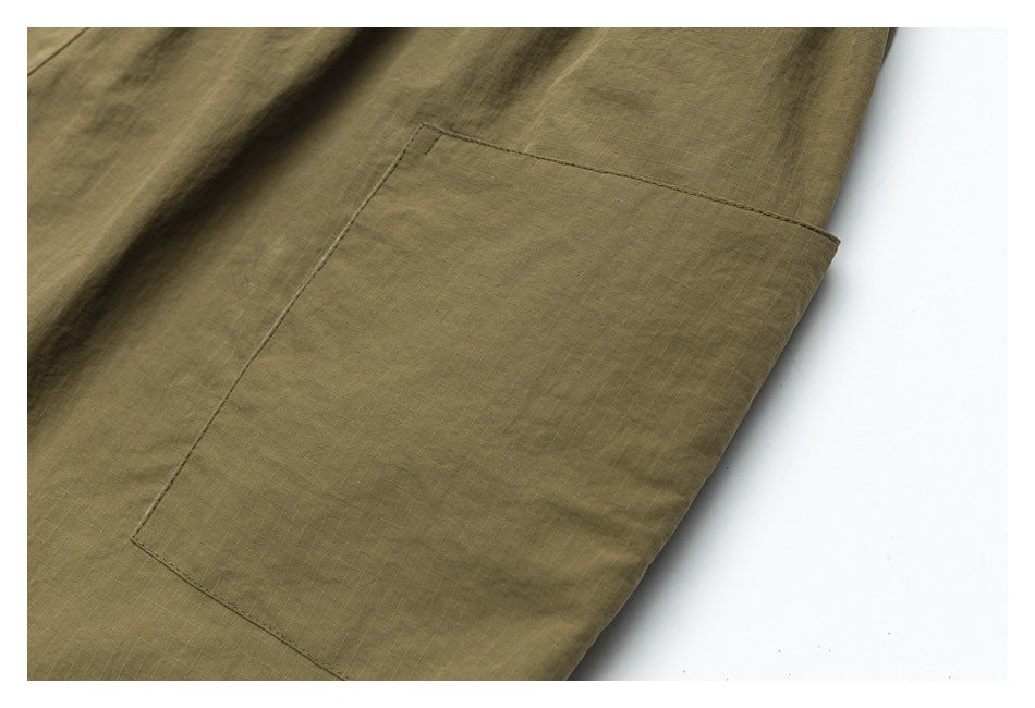 Close-up of a large rectangular patch pocket on olive-khaki pants.